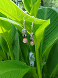 Pair of beaded earrings on a green leafy background