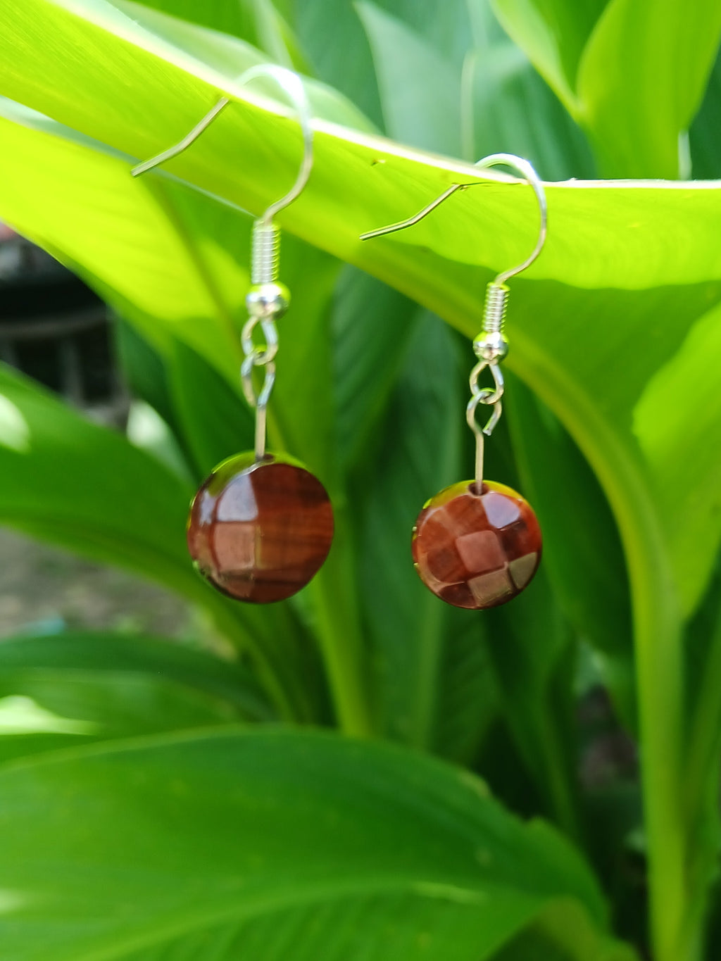 Jewelry with red stones on a green leaf background